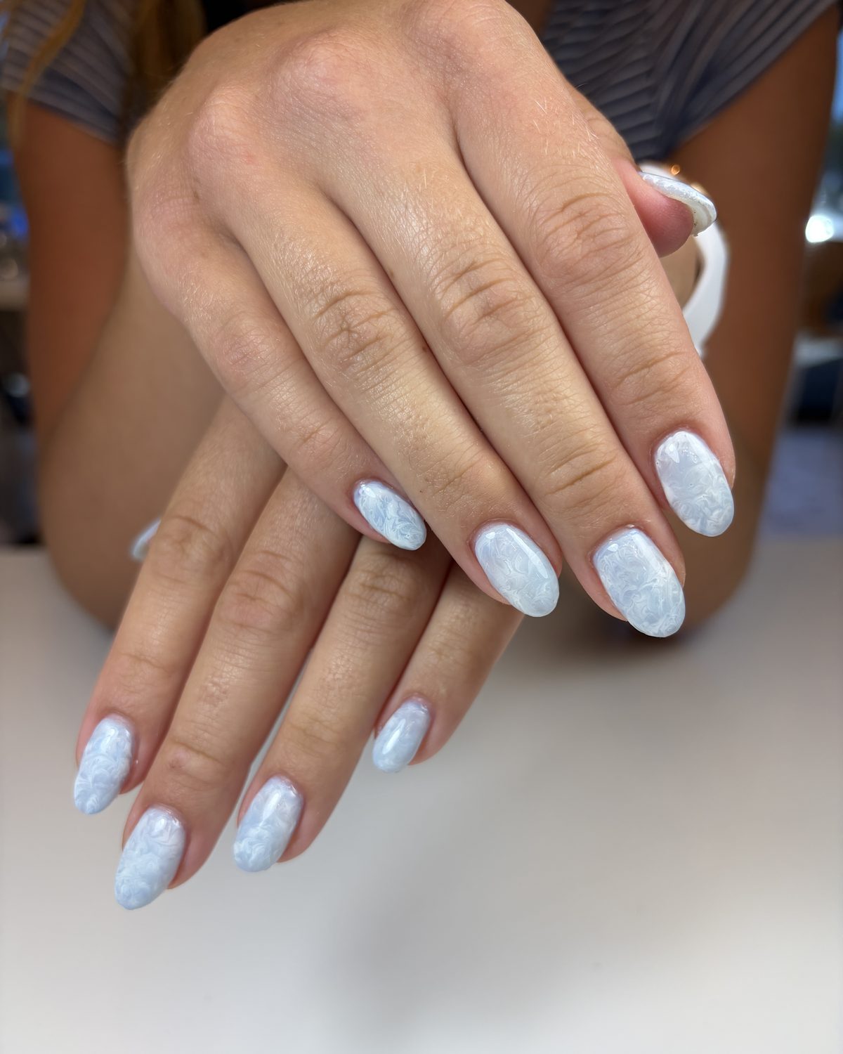 Oval nails in a pale blue marble.