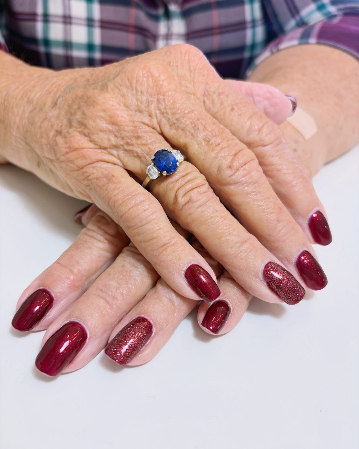 Deep burgundy gel with glitter accent nails.
