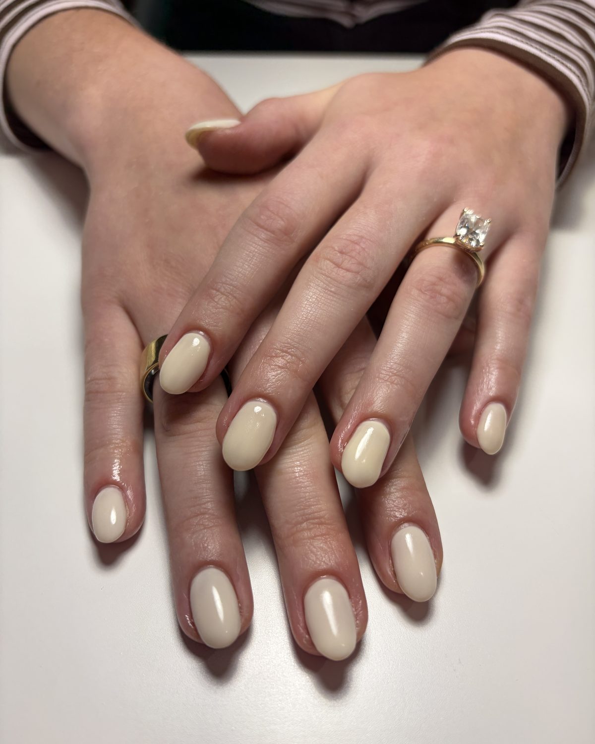 Glossy cream nails, short and oval.